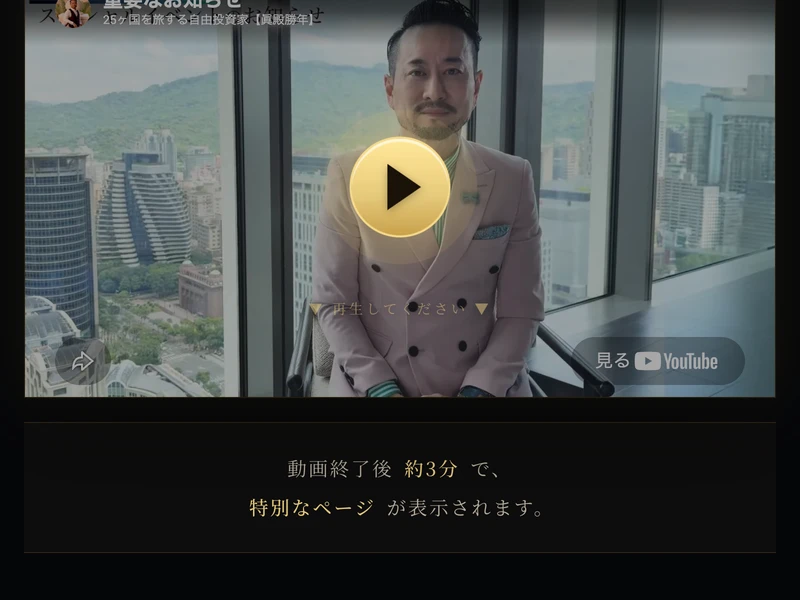 眞殿勝年の動画。ピンクのジャケットを着た男性が高層ビルの前に立っている